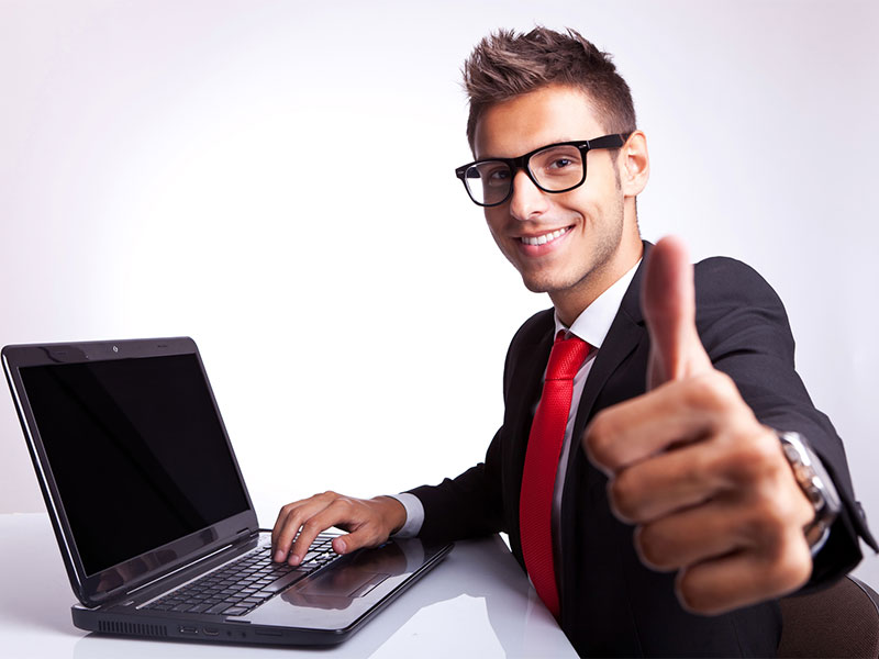 man giving thumbs up next to computer