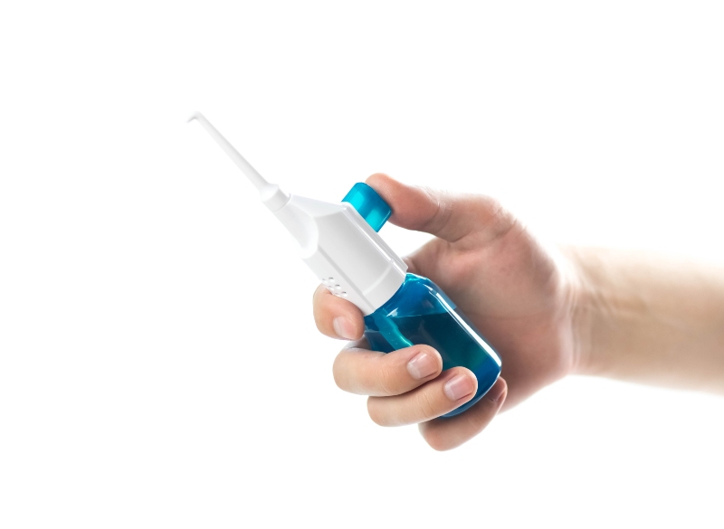 Hand holding a water flosser over white background